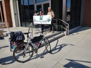 People hold a sign celebrating Transit Equity Day